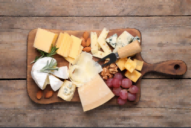 cheese-plate-with-grapes-and-nuts-on-wooden-table-top-view