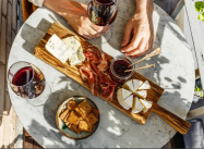 varied-appetizer-cheese-board-with-soft-cheese-fruit-sauce-and-red-wine-on-marble-table-for-small